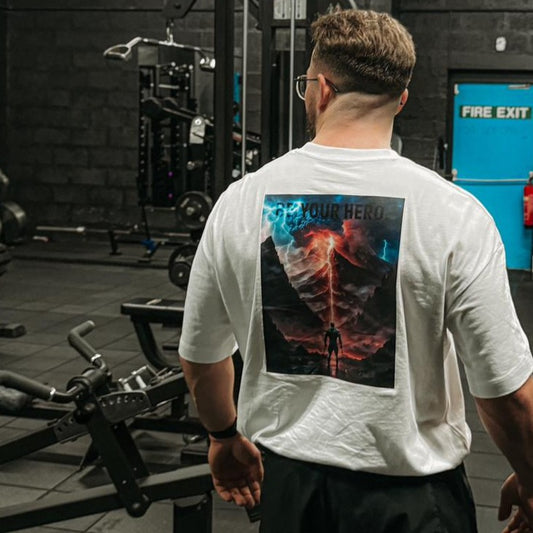 Turn heads as you make a statement from behind with our captivating back design. Behold our mysterious hero, stoically gazing at an apocalyptic volcano eruption, lightning striking all around. The scene is not just epic; it's a visual representation of overcoming challenges and embracing your inner strength. Captioned with the empowering words, "BE YOUR HERO," this shirt serves as a constant reminder to rise above adversity and conquer your personal mountains.